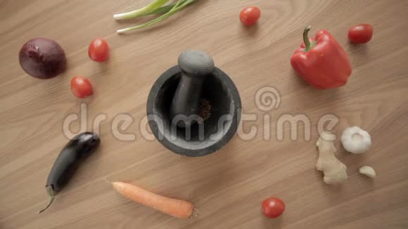 用灰浆和杵在橡木桌中央用蔬菜手工研磨香料视频的预览图