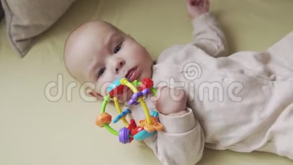 可爱的小宝宝用手拿玩具看相机的俯视图视频的预览图