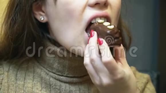 女人吃一个带坚果的巧克力蛋糕特写视频的预览图