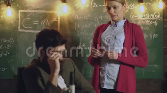 教师在黑板背景上工作老师和学生学习观念老师坐在桌子旁视频的预览图