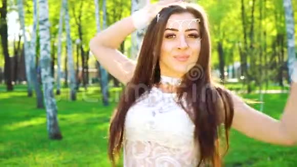 白桦林中穿着性感裙子在阳光下跳舞的漂亮年轻女子的肖像视频的预览图
