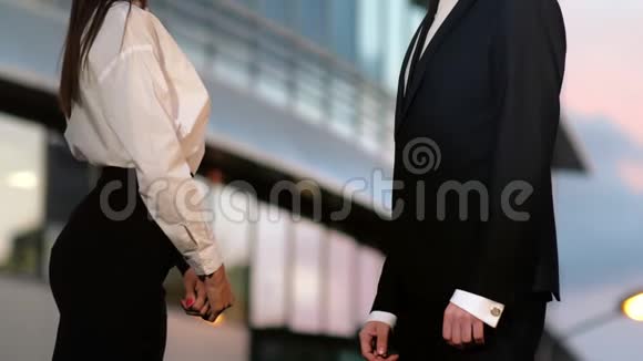 在商业大厦的室外商务男性和商务女性之间握手视频的预览图
