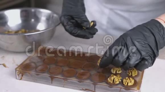 贝克双手把核桃的一半放在巧克力糖果上视频的预览图