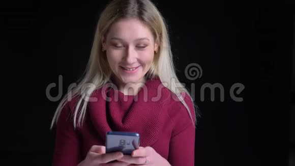 年轻漂亮的白种人金发女性在寺庙附近用微笑和扭曲手指的电话特写镜头视频的预览图