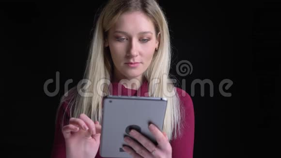 年轻漂亮的白种人女性使用平板电脑的特写镜头在镜头前兴奋起来视频的预览图