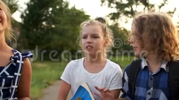 三个孩子正在从乡村学校回来男孩提着一个公文包女孩提着书和一个大箱子视频的预览图