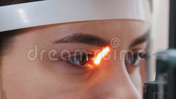 眼科治疗一名年轻女子用一台特殊的大光镜检查视力棕色视频的预览图