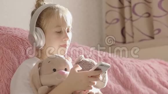 一个女孩在房间里的地板上玩手机还有她最喜欢的玩具视频的预览图