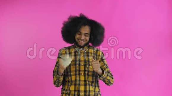 快乐的年轻非裔美国人手里拿着钱看着紫色背景的相机视频的预览图