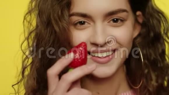 性感的女孩在工作室吃草莓水果吃草莓的年轻女人视频的预览图