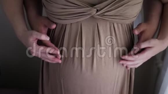 穿棕色裙子的孕妇和穿白色t恤的丈夫视频的预览图