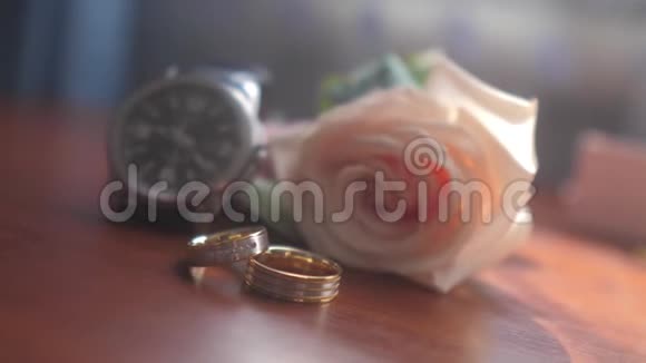 结婚饰品腕表金色戒指一束美丽的花束在棕色纹理的桌子上新娘的概念视频的预览图