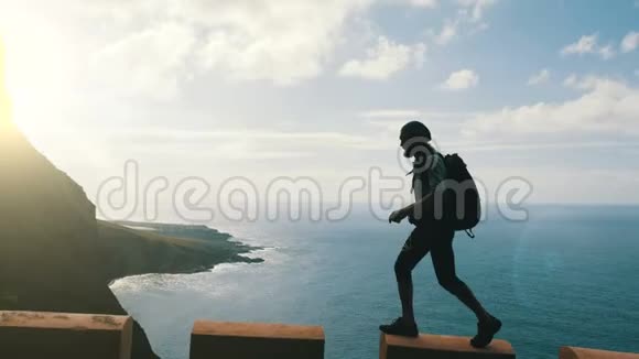 马累徒步旅行者的剪影背着背包走在大洋上方加那利群岛上的一条路的边缘视频的预览图