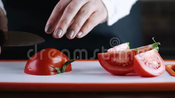 一个新鲜的番茄正被切在切割板上视频的预览图
