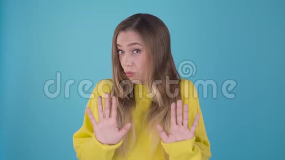 哇哇放松点一个蓝色背景上有魅力的女孩用她的手展示了一个足够的手势蓝色隔离视频的预览图