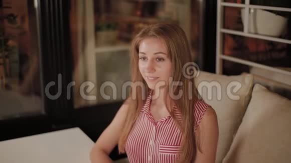 美丽的女孩在一家晚间咖啡馆等待她的点菜视频的预览图