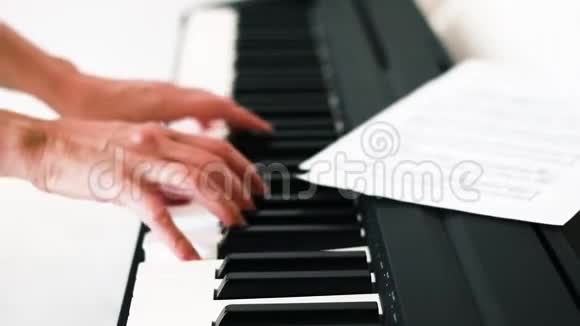 弹钢琴的女人白色背景下的钢琴键盘和女子手视频的预览图