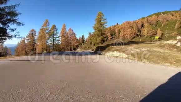 在一个美妙的秋日山路行驶五颜六色的树木和蓝天视频的预览图