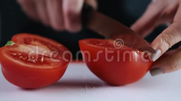 一个新鲜的番茄正被切在切割板上视频的预览图