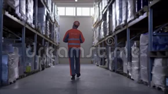 仓库工作人员戴着戴着安全帽和制服的眼镜在审计期间在平板电脑上做笔记视频的预览图