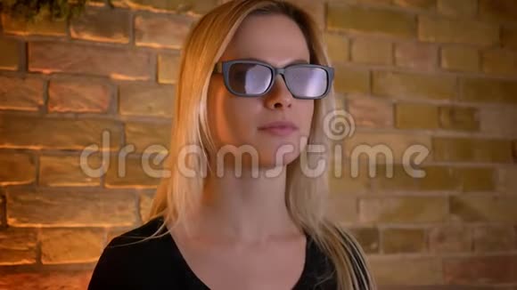 年轻女性青少年在电视上戴眼镜看一部3D恐怖电影的特写镜头并在坐着的时候得到一个跳跃镜头视频的预览图
