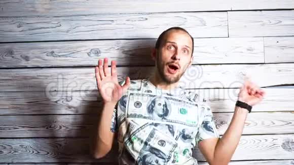 一个穿着一美元t恤的疯狂快乐男人在成功时重归于好微笑着跳跃着关于意外问题的概念视频的预览图