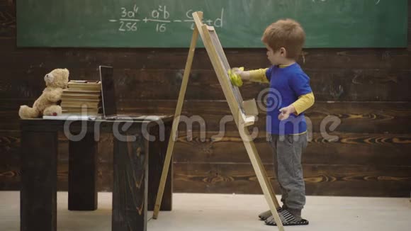 用粉笔在黑板上书写的男孩的特写小艺术家在木制背景上画画美术概念视频的预览图
