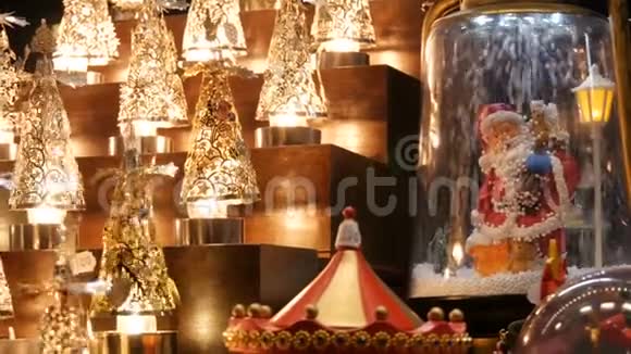 美丽舒适明亮的圣诞灯和圣诞老人雕像市场柜台上的人造雪落在上面视频的预览图