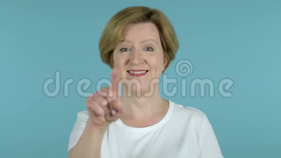 老女人用双手在蓝色背景下邀请顾客视频的预览图