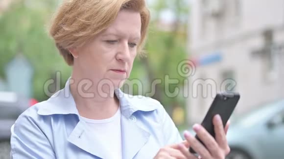 户外老年妇女应对智能手机丢失视频的预览图