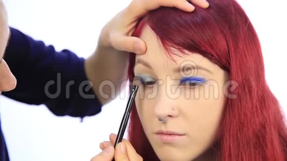 化妆师和模特一起工作艺术家用特殊画笔手的特写镜头视频的预览图
