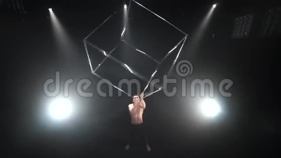 马戏团男性肌肉表演者在黑色背景下用杂耍立方体道具做把戏集中概念视频的预览图
