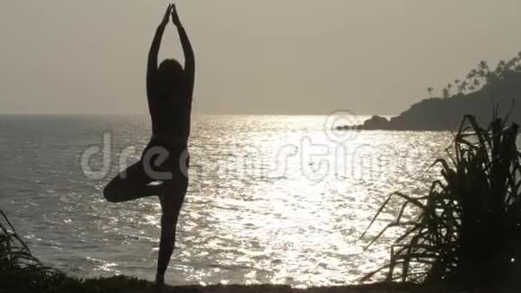 年轻女子站在腿上做瑜伽姿势对抗水视频的预览图