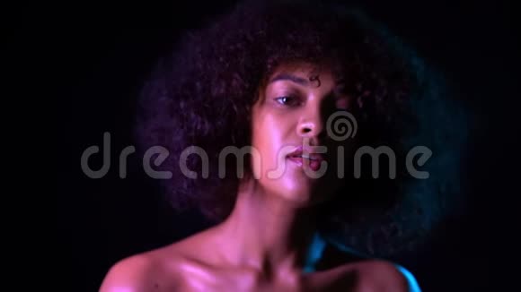 年轻混血女孩的肖像健康的皮肤观念积极可爱的女人化妆摆在黑色的黑暗房间里视频的预览图