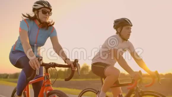 空的空间在日落时骑自行车运动的朋友一对骑自行车的人沿着海岸走自然背景下的运动小组视频的预览图