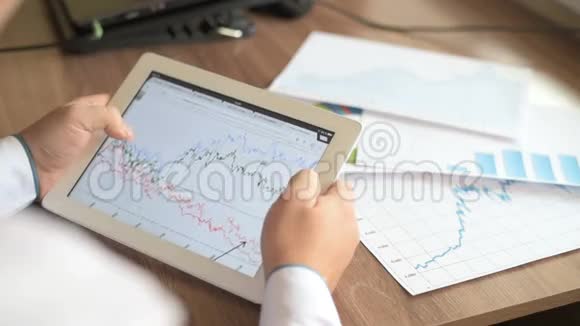 在平板电脑上工作的商人用图表用手指触摸金融市场的饼图视频的预览图