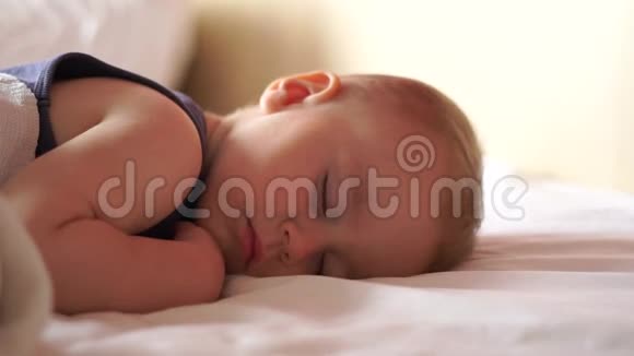 年轻的妈妈亲吻婴儿的脸颊而他却以缓慢的动作甜蜜地睡觉视频的预览图