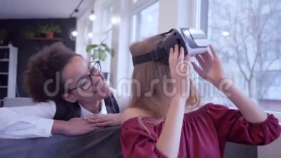 虚拟现实娱乐微笑多民族朋友女孩游戏虚拟现实使用专用VR耳机特写视频的预览图
