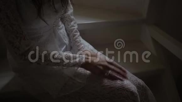 一个穿着白色外套的女孩坐在楼梯上手上拿着订婚戒指视频的预览图