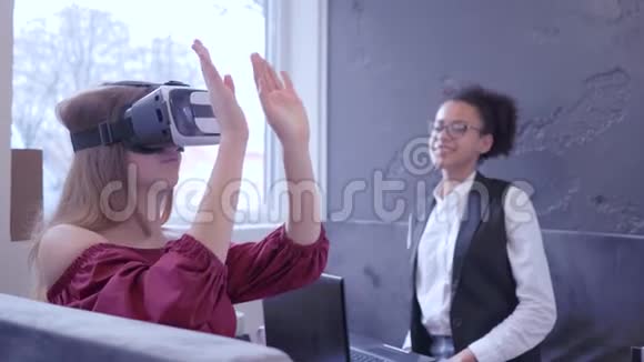 未来欢乐的国际朋友女孩用VR面具和现代笔记本电脑技术游戏虚拟现实视频的预览图