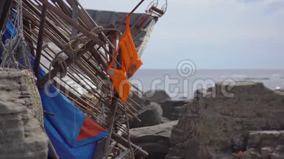 一件救生衣挂在岩石海边的一艘渔船的残骸上沉船的概念一个人都没有活下来视频的预览图