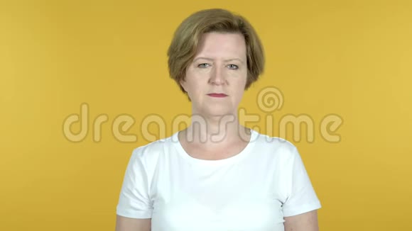 拒绝老年妇女在黄色背景下的脱佣视频的预览图
