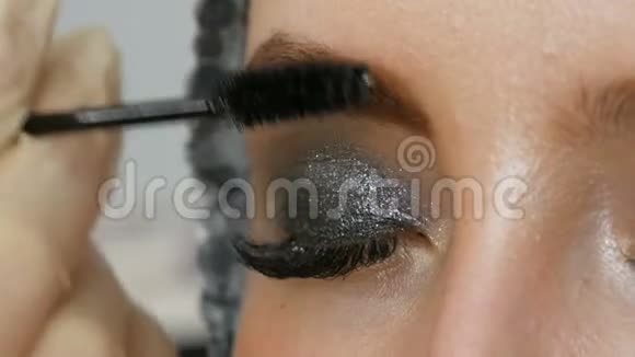 专业妆高时尚女孩模特用特殊的眉毛刷画眉毛时尚的烟熏眼视频的预览图