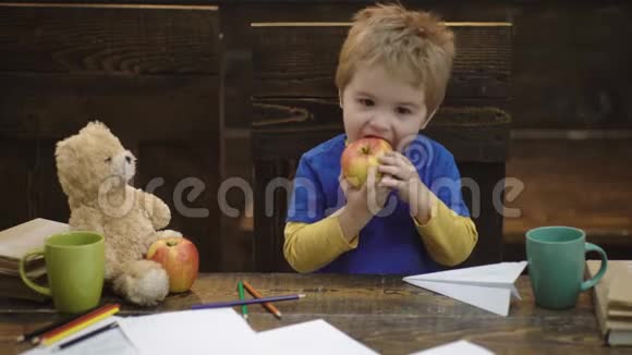 快乐的孩子玩得开心可爱的男孩吃着美味的苹果孩子和最喜欢的玩具分享零食小学生在视频的预览图