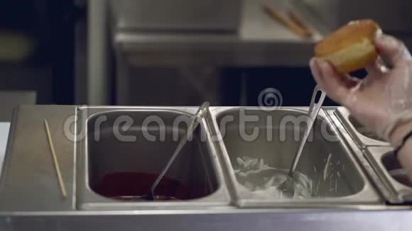 厨师正把一个甜甜圈放进乳白色的釉里视频的预览图