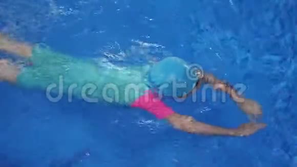 小女孩正在学习游泳在游泳池潜水和漂浮在水中视频的预览图