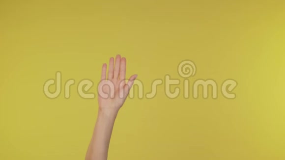 女人挥手告别因为在4K演播室的黄色背景下有人与朋友隔绝视频的预览图