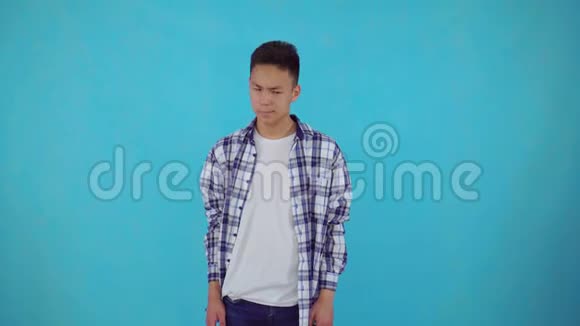 蓝色背景的一个糊涂的亚洲年轻人视频的预览图