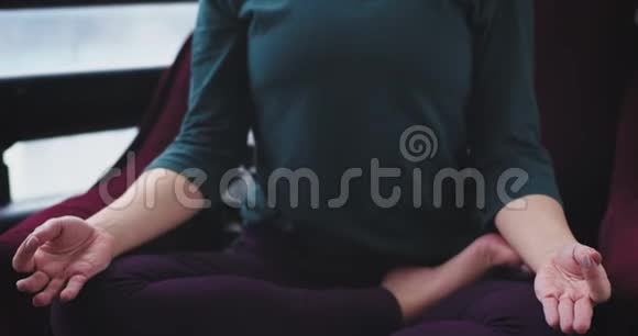 在家里特写女士在红色沙发上做了一个冥想瑜伽姿势她闭着眼睛集中着脸以获得视频的预览图