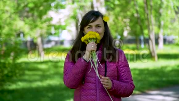 年轻的女人嗅着黄色的蒲公英视频的预览图